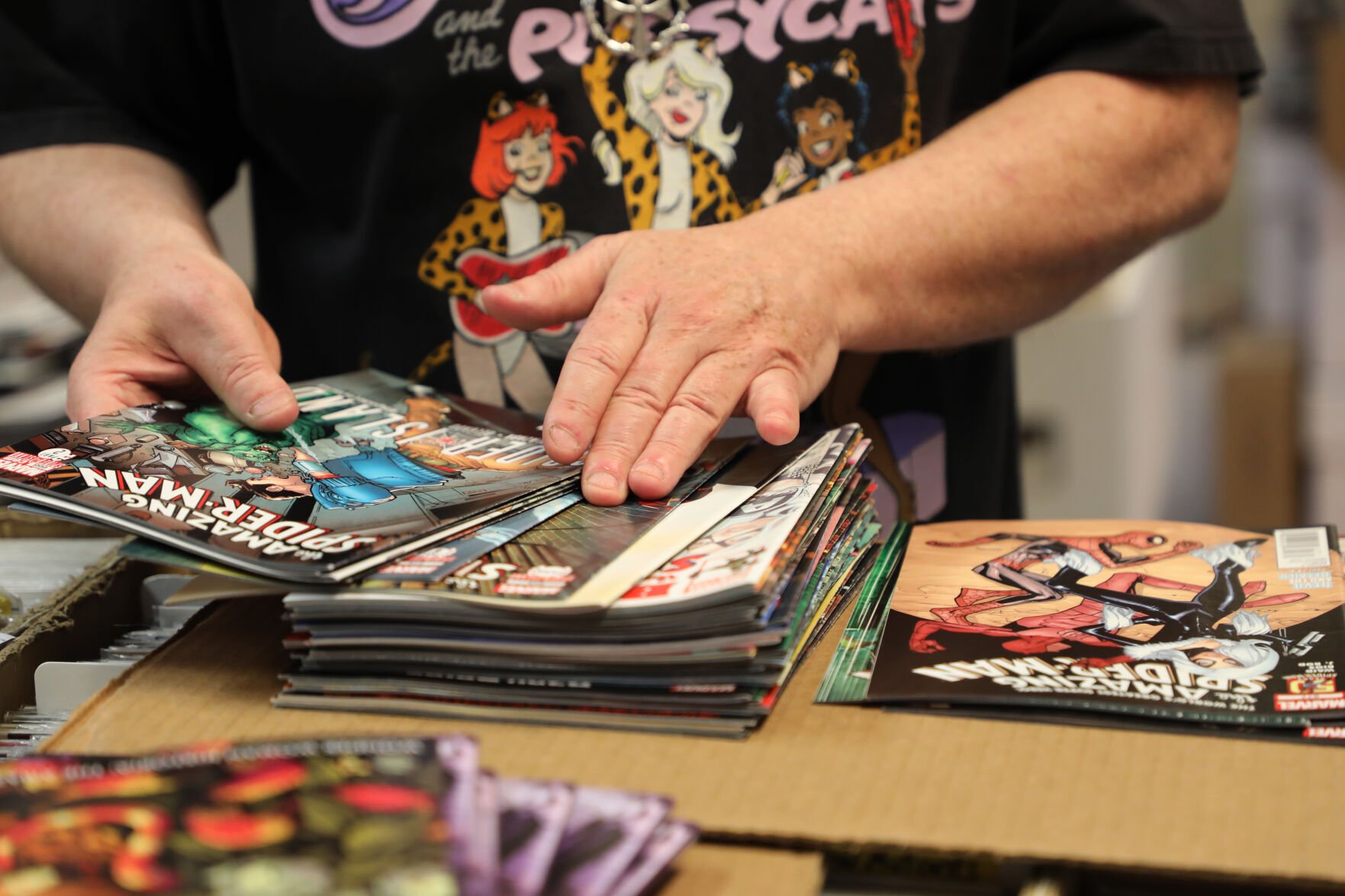 John Evans sorts through a stack of Spider-Man comics